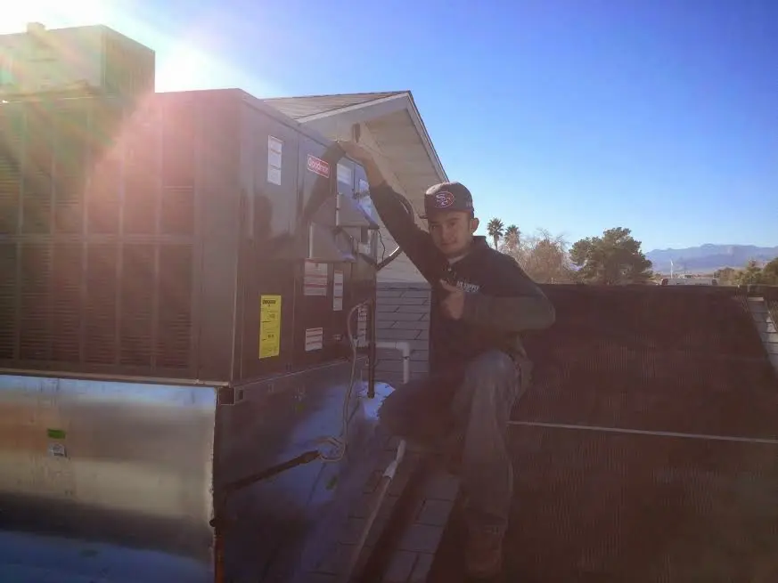 HVAC technician performing Air Duct Repair on a rooftop unit in Oro Valley